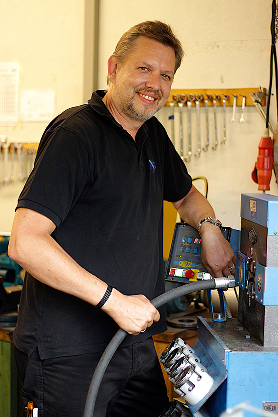 Mitarbeiter verpresst Hydraulikschlauch an Schlauchpresse